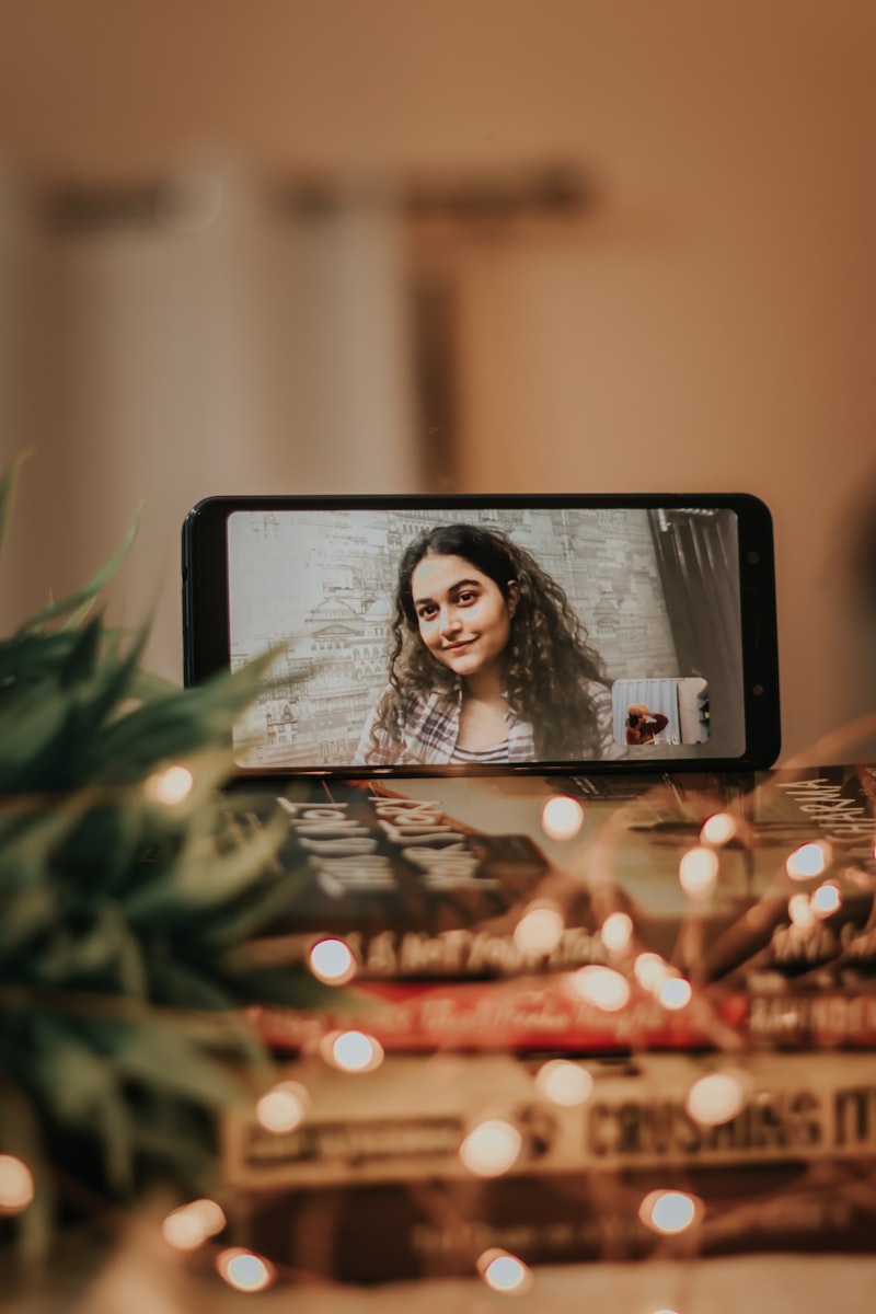 Person recording video message on smartphone with warm home background